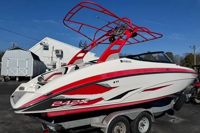 Slide: The Image of 2020 Yamaha Boats 242X E-Series on trailer, featuring sleek red and white design. - 1