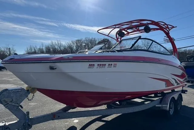 Slide: The Image of 2020 Yamaha Boats 242X E-Series on trailer, red and white design, parked outdoors. - 3