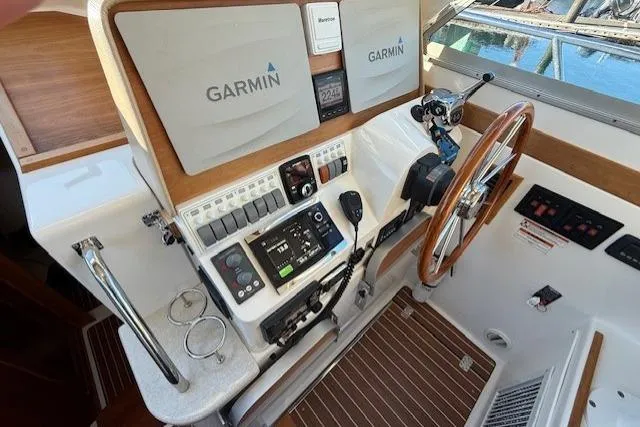Slide: The Image of Helm station of 2015 Back Cove 37 with Garmin navigation equipment and wooden steering wheel. - 16