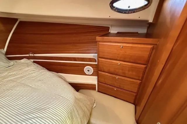 Slide: The Image of 2015 Back Cove 37 cabin interior with wooden drawers and striped bedding. - 21