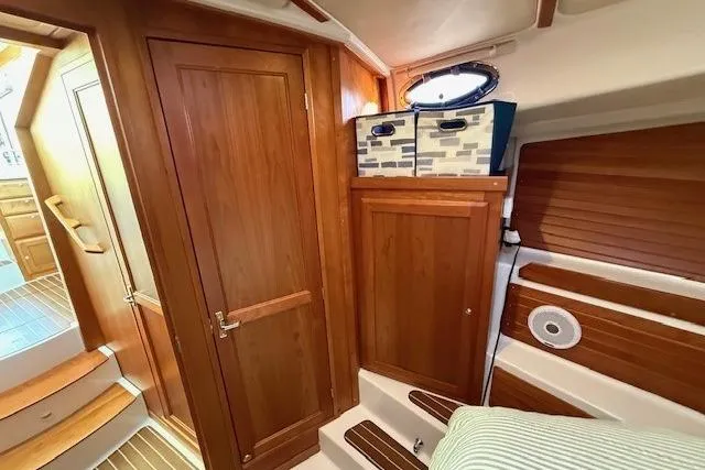Slide: The Image of 2015 Back Cove 37 interior with wooden cabinetry and cozy seating area. - 22