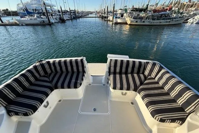 Slide: The Image of 2015 Back Cove 37 yacht with striped seating, docked in a marina. - 25