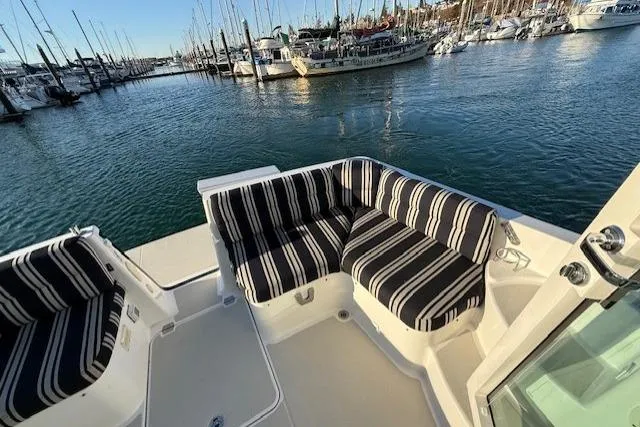Slide: The Image of 2015 Back Cove 37 yacht with striped seating, docked in a marina. - 26