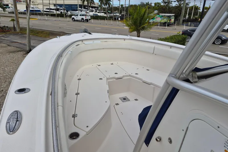 Slide: The Image of 2014 Robalo R300 Center Console boat, spacious deck, parked near a road. - 11