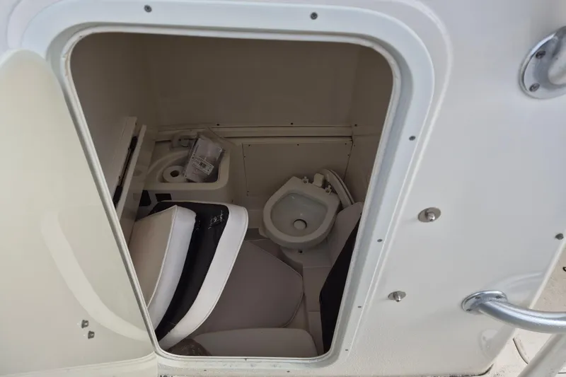 Slide: The Image of 2014 Robalo R300 Center Console boat interior with compact marine toilet. - 14