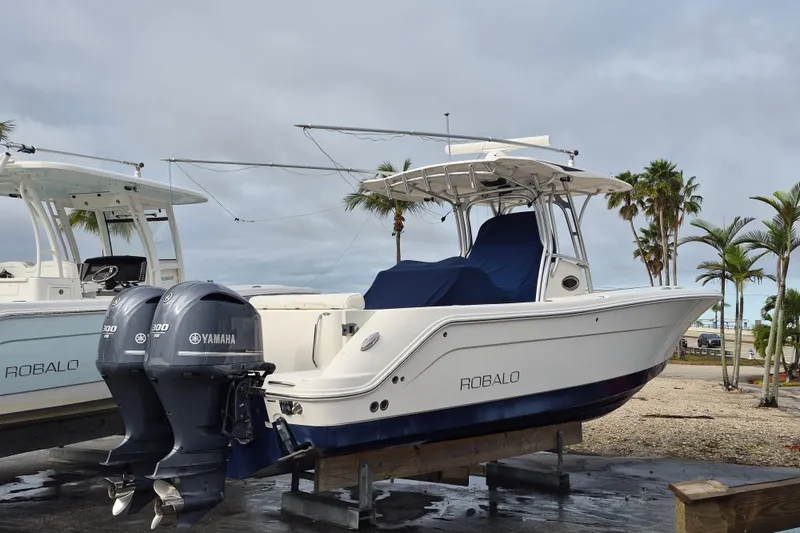 Slide: The Image of 2014 Robalo R300 Center Console boat with twin Yamaha engines on display. - 2