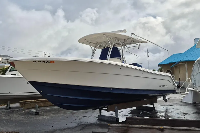 Slide: The Image of 2014 Robalo R300 Center Console boat on display, featuring a sleek white and blue design. - 3