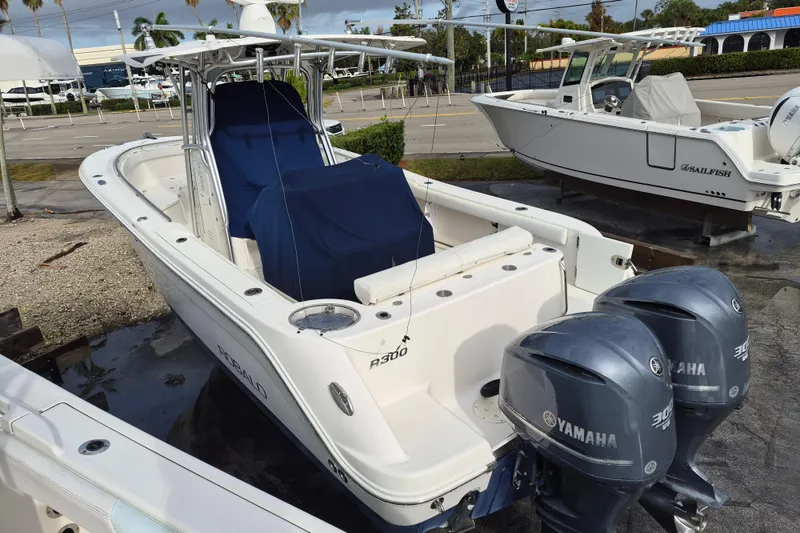 Slide: The Image of 2014 Robalo R300 Center Console boat with twin Yamaha engines, docked outdoors. - 5
