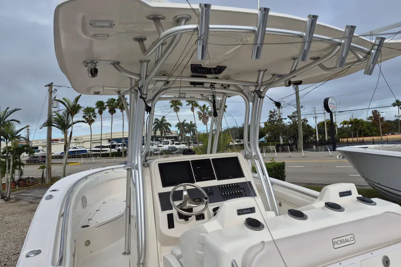 Slide: The Image of 2014 Robalo R300 Center Console boat with T-top and dual helm seats. - 6