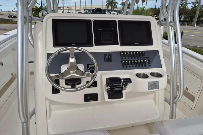 Slide: The Image of 2014 Robalo R300 Center Console boat dashboard with steering wheel and control panel. - 7