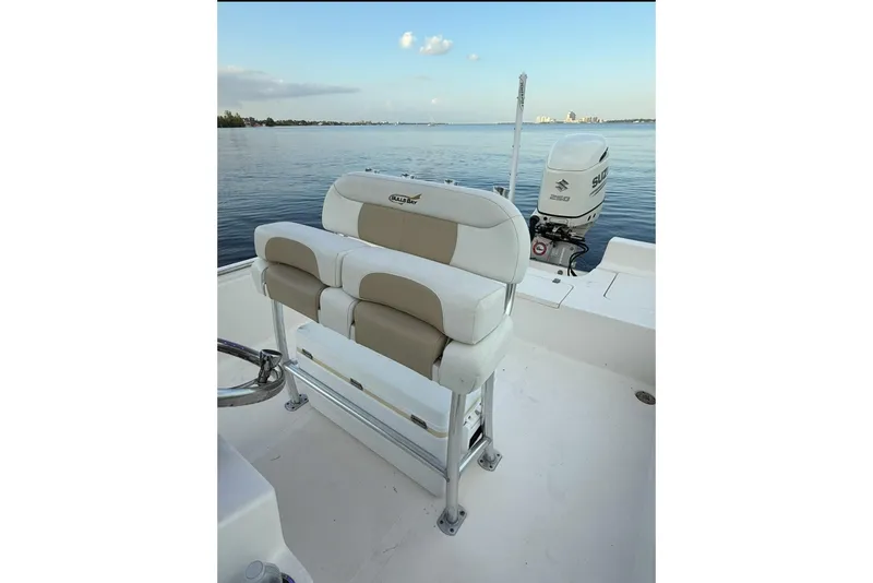Slide: The Image of 2020 Bulls Bay 2400 boat interior with seating and Suzuki outboard motor on calm water. - 36