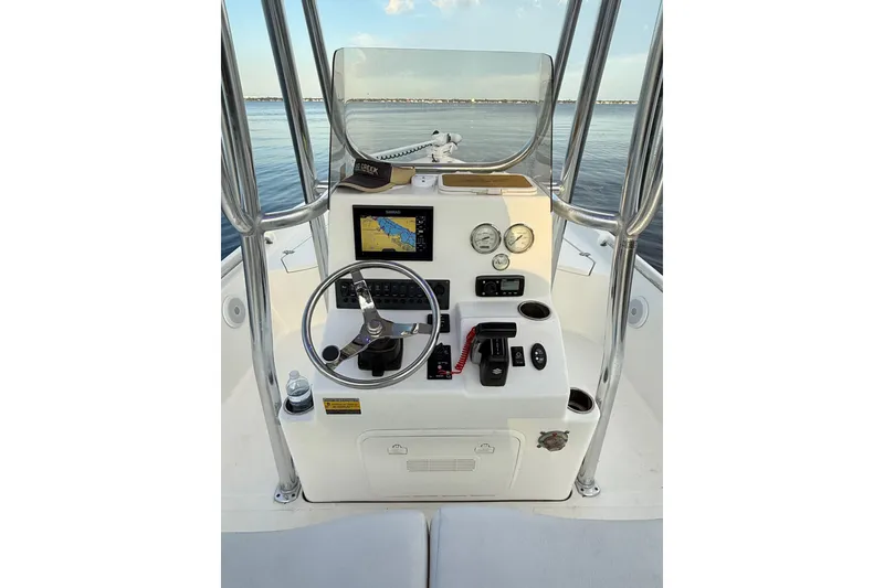 Slide: The Image of 2020 Bulls Bay 2400 boat console with steering wheel, navigation system, and gauges on calm water. - 38