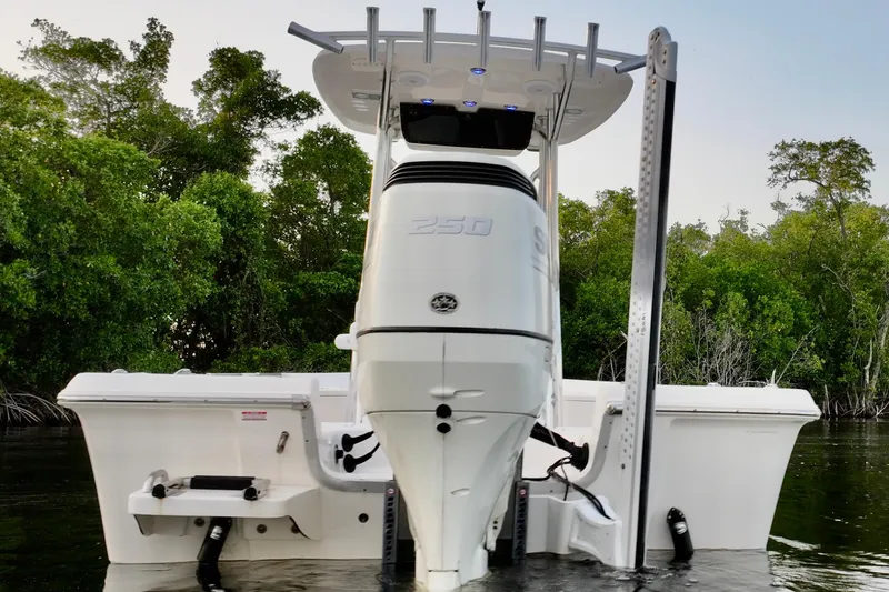 Slide: The Image of 2020 Bulls Bay 2400 boat with powerful outboard motor, docked near lush greenery. - 41