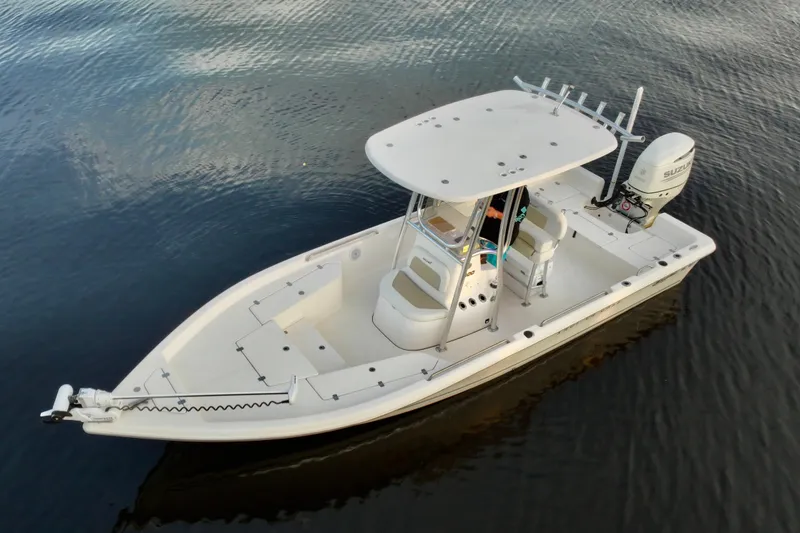 Slide: The Image of 2020 Bulls Bay 2400 boat on calm water, featuring a sleek design and outboard motor. - 7