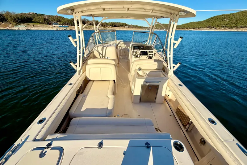 Slide: The Image of 2019 Grady-White Freedom 285 boat on serene blue water, showcasing spacious deck and seating. - 14