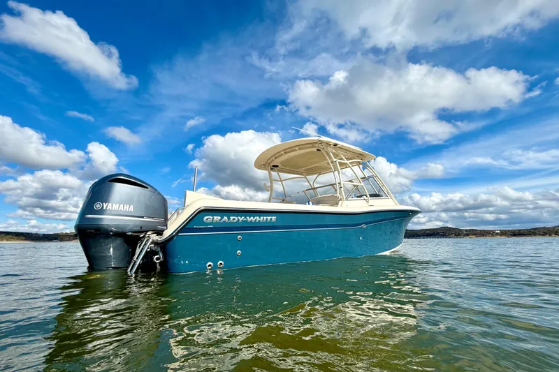 Slide: The Image of 2019 Grady-White Freedom 285 boat on water under blue sky with clouds. - 2