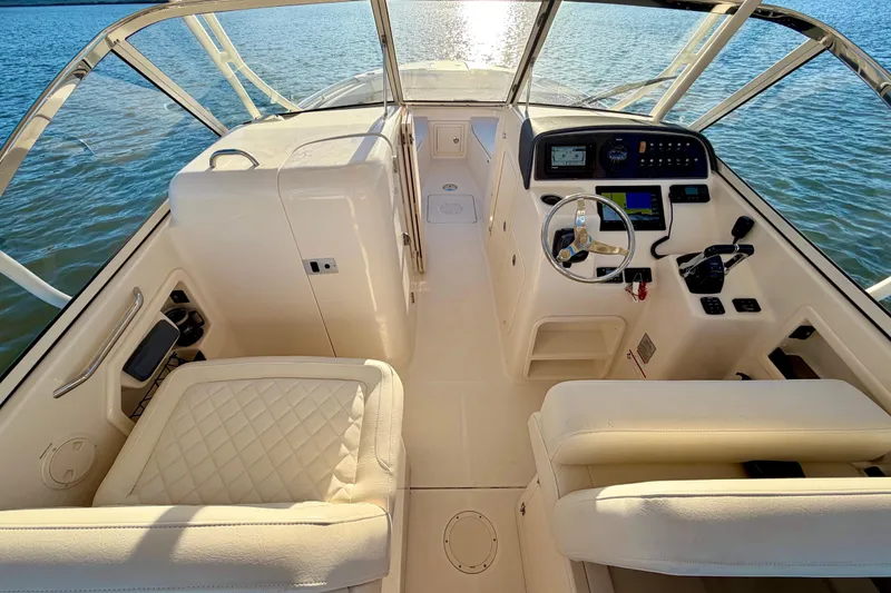 Slide: The Image of 2019 Grady-White Freedom 285 boat interior with helm, seats, and water view. - 22
