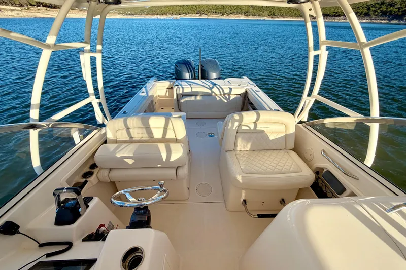 Slide: The Image of 2019 Grady-White Freedom 285 boat interior with seating, steering wheel, and open water view. - 24
