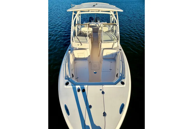 Slide: The Image of 2019 Grady-White Freedom 285 boat on calm water, showcasing spacious deck and seating. - 27