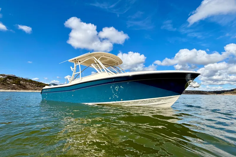 Slide: The Image of 2019 Grady-White Freedom 285 boat on water under blue sky with clouds. - 3