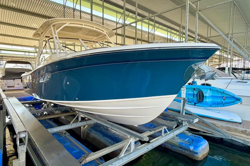 Slide: The Image of 2019 Grady-White Freedom 285 boat in marina, blue hull, docked on lift. - 33