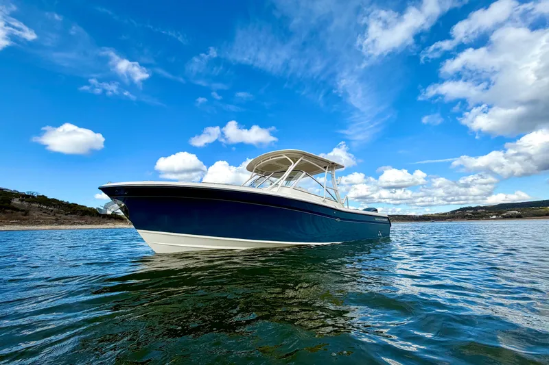 Slide: The Image of 2019 Grady-White Freedom 285 boat on water under blue sky. - 6