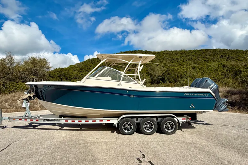 Slide: The Image of 2019 Grady-White Freedom 285 boat on trailer, parked outdoors under blue sky. - 62