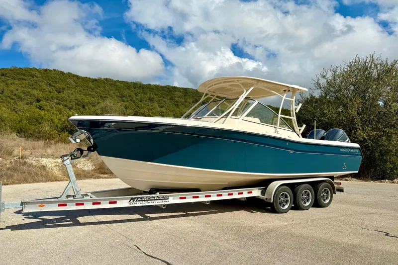 Slide: The Image of 2019 Grady-White Freedom 285 boat on trailer, parked outdoors under a cloudy sky. - 63