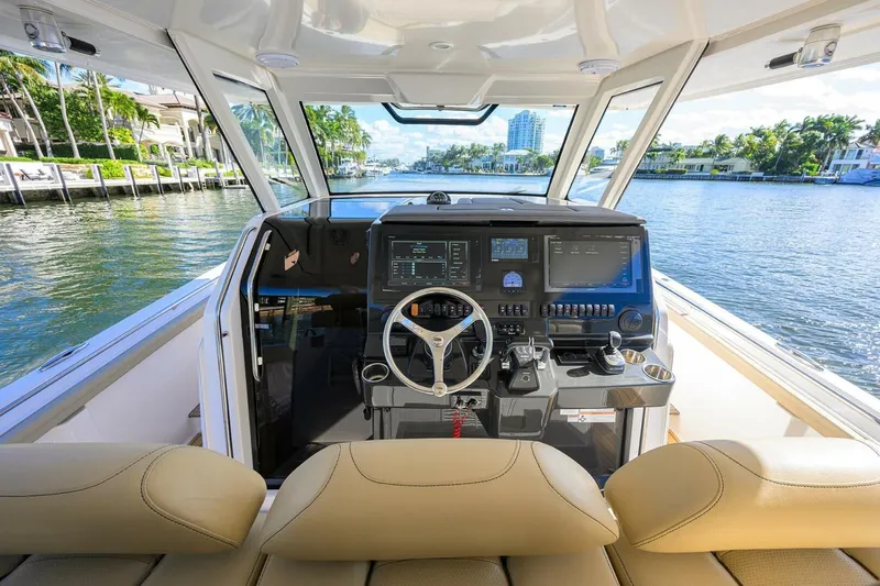 Slide: The Image of 2018 Pursuit S 408 Sport boat cockpit with modern controls and waterfront view. - 12
