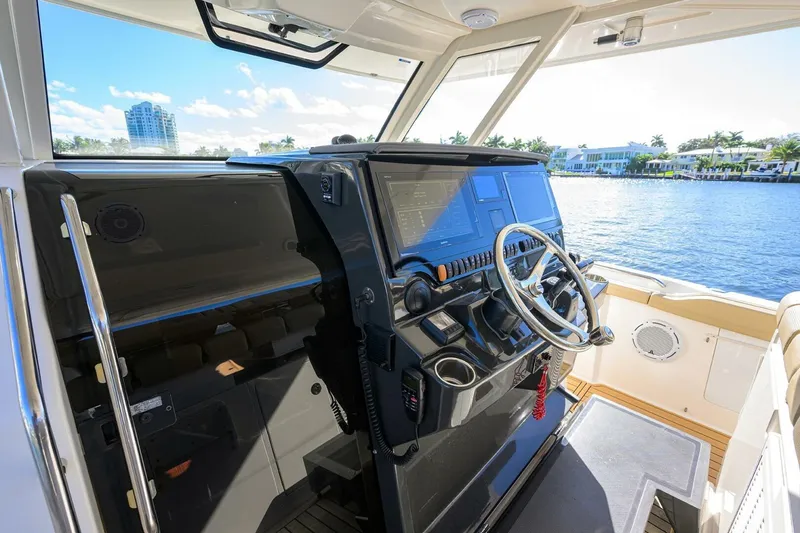 Slide: The Image of 2018 Pursuit S 408 Sport boat helm with modern controls and waterfront view. - 13