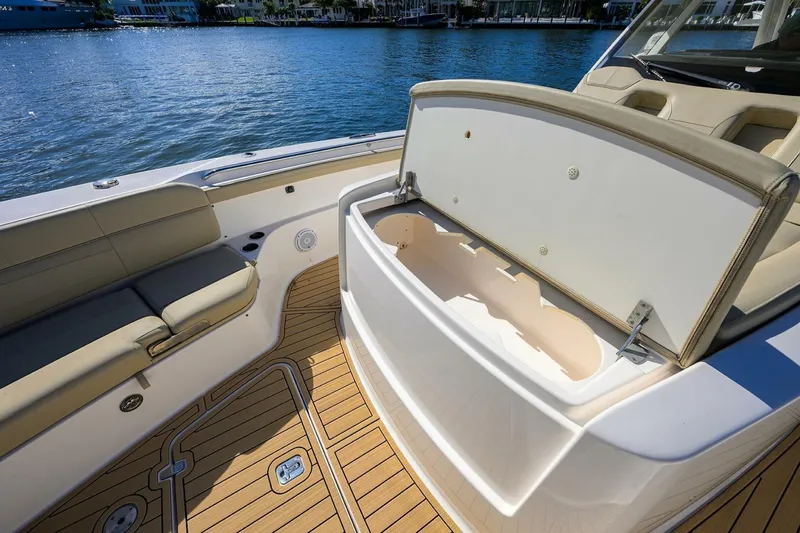 Slide: The Image of 2018 Pursuit S 408 Sport boat interior with open storage compartment and cushioned seating. - 17