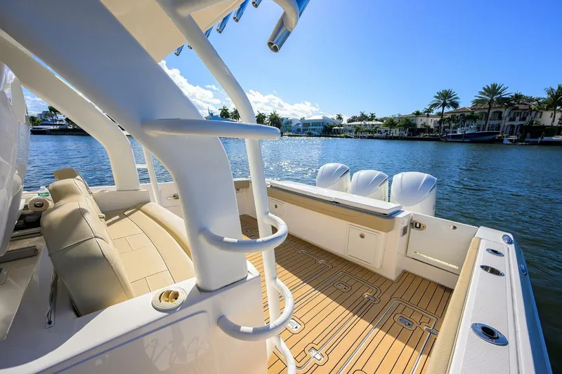 Slide: The Image of 2018 Pursuit S 408 Sport boat with luxurious deck, docked by waterfront homes. - 19