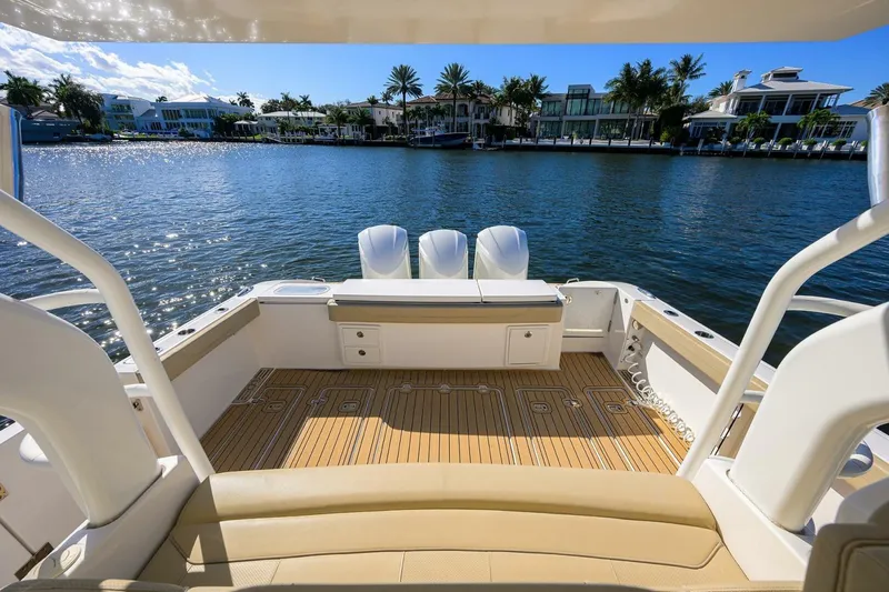 Slide: The Image of 2018 Pursuit S 408 Sport boat with spacious deck overlooking waterfront homes. - 21