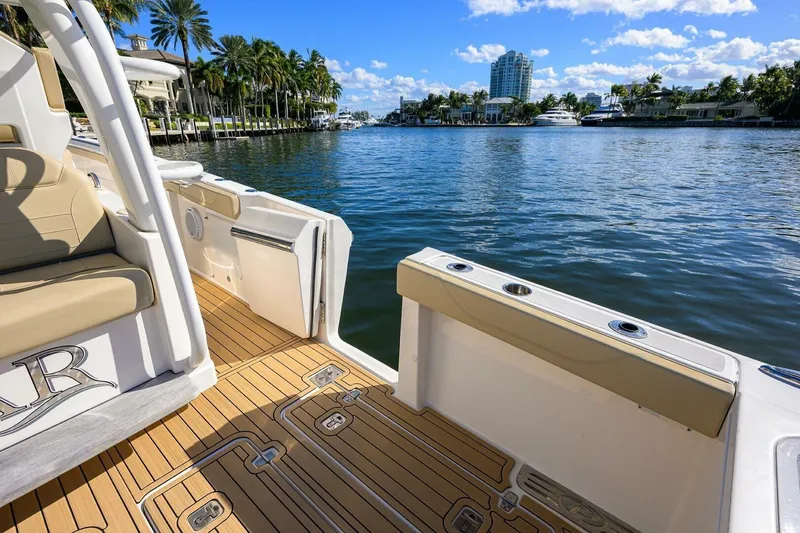 Slide: The Image of 2018 Pursuit S 408 Sport boat on scenic waterfront with palm trees and clear skies. - 24