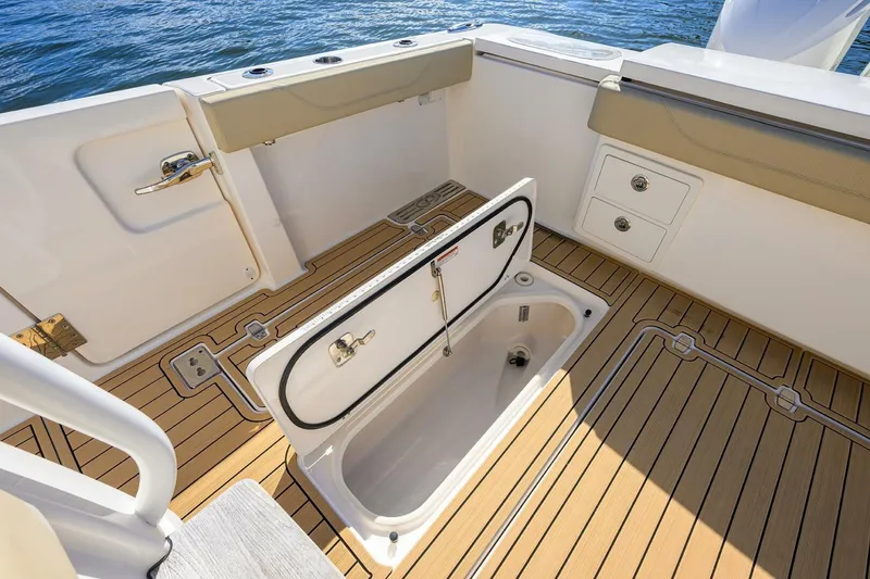 Slide: The Image of 2018 Pursuit S 408 Sport boat deck with open storage compartment. - 25