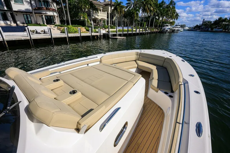 Slide: The Image of 2018 Pursuit S 408 Sport boat with luxurious seating on a scenic waterfront. - 41