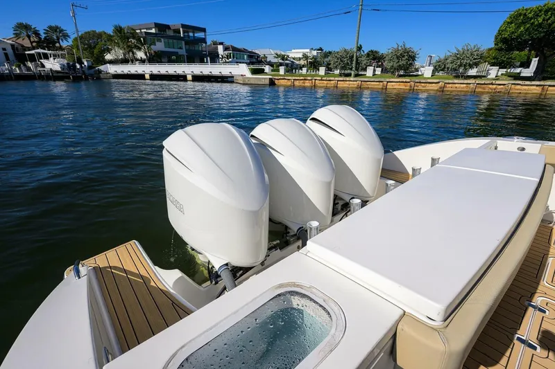 Slide: The Image of 2018 Pursuit S 408 Sport boat with triple outboard engines on a sunny waterfront. - 44