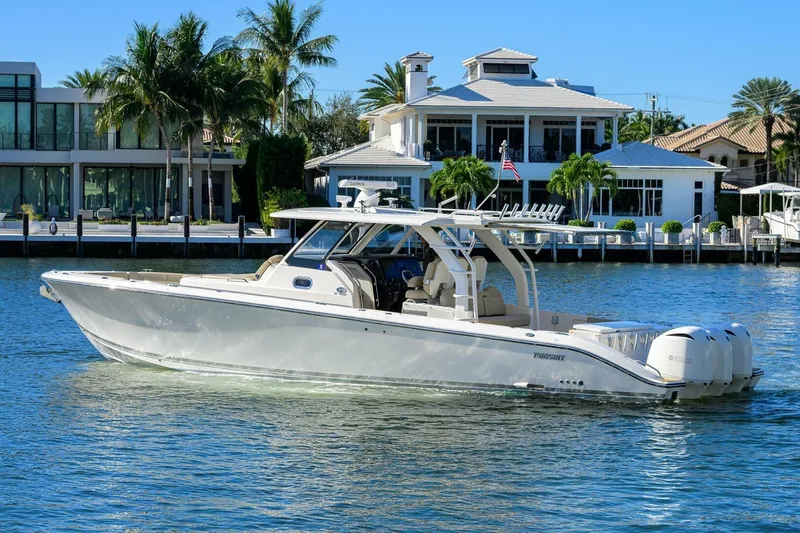 Slide: The Image of 2018 Pursuit S 408 Sport boat cruising near waterfront homes. - 49