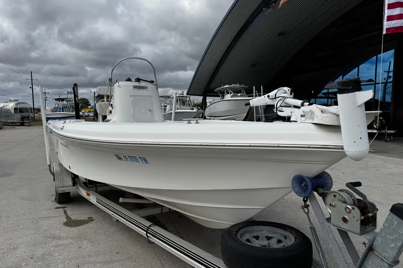 Slide: The Image of 2005 Sea Fox 205 Bay Fisher boat on trailer, parked near a modern building under cloudy skies. - 9