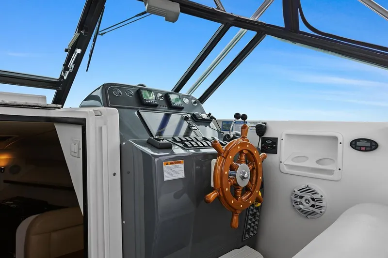 Slide: The Image of 2005 Tiara Open Classic boat helm with wooden steering wheel and modern controls. - 10