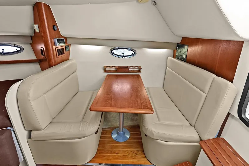 Slide: The Image of 2005 Tiara Open Classic interior with beige seating and wooden table. - 18