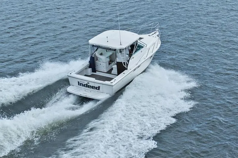 Slide: The Image of 2005 Tiara Open Classic boat cruising on open water, rear view. - 2