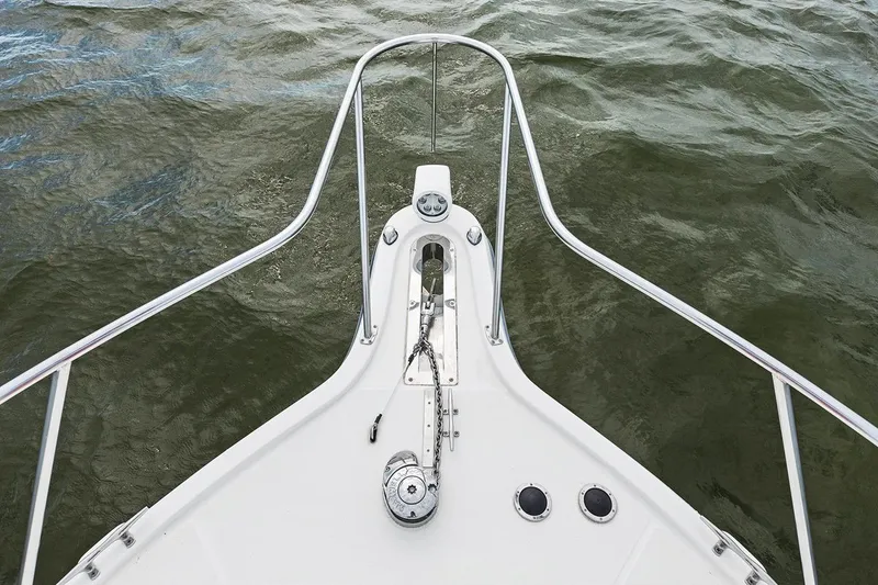 Slide: The Image of Bow of 2005 Tiara Open Classic boat with anchor and railing on water. - 4