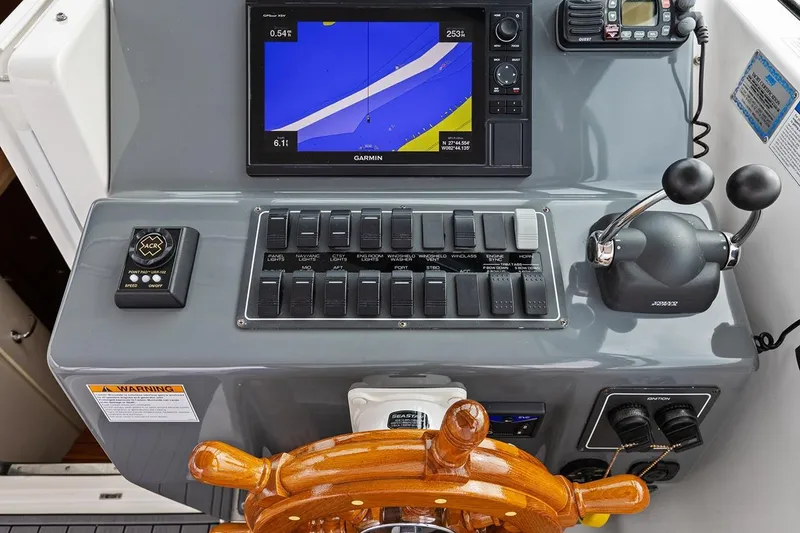 Slide: The Image of 2005 Tiara Open Classic boat dashboard with navigation controls and wooden steering wheel. - 9