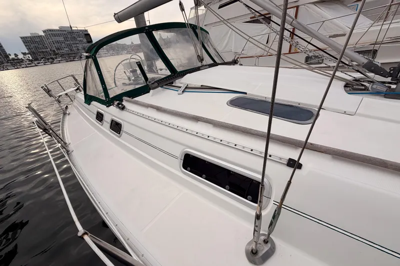Slide: The Image of 1997 Beneteau Oceanis 351 sailboat docked, featuring green canopy and sleek white deck. - 17
