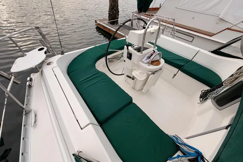 Slide: The Image of Cockpit of 1997 Beneteau Oceanis 351 sailboat with green cushions and steering wheel. - 19