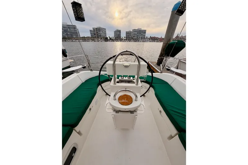 Slide: The Image of 1997 Beneteau Oceanis 351 sailboat cockpit with green seating, city skyline in background. - 20