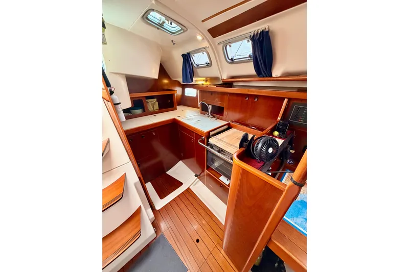 Slide: The Image of Interior of 1997 Beneteau Oceanis 351 sailboat with wooden cabinetry and compact kitchen. - 35