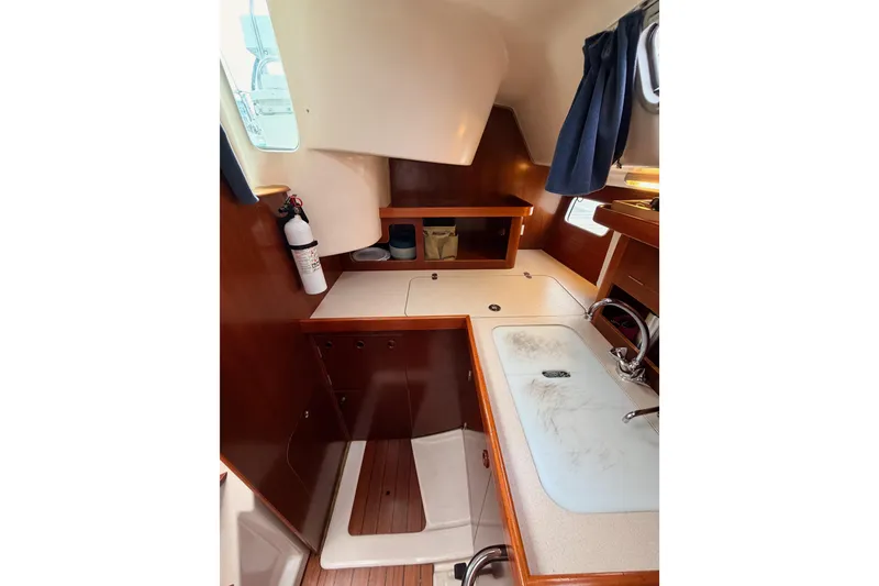 Slide: The Image of Interior of 1997 Beneteau Oceanis 351 sailboat with wooden cabinetry and compact kitchen area. - 36