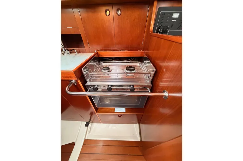 Slide: The Image of Galley kitchen in 1997 Beneteau Oceanis 351 sailboat with stove and wooden cabinetry. - 38